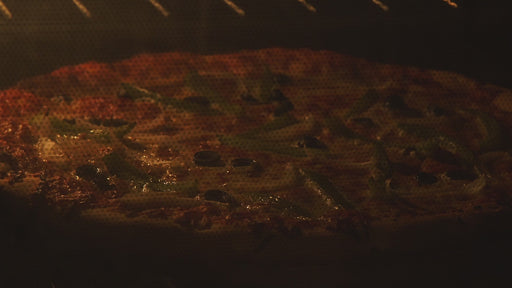 video of hot sauce being poured on  cooked pizza